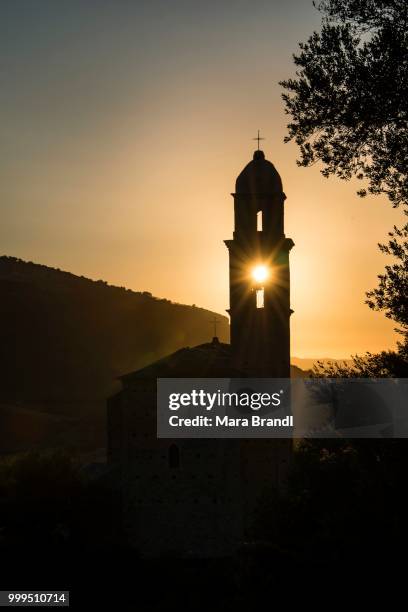 sun shining through a belfry, silhouette of a church tower, evening mood, sunset, haute-corse, corsica, france - haute corse fotografías e imágenes de stock