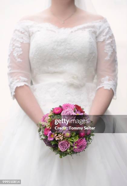 bride holding wedding bouquet - female anatomy stock-fotos und bilder