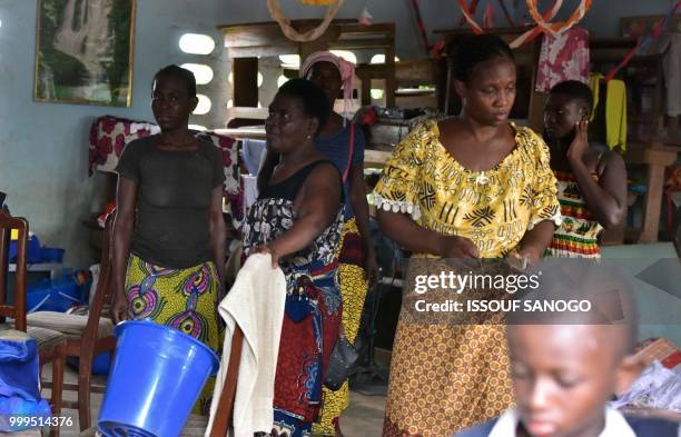 This picture taken on July 14, 2018 shows people who found shelter at a school after their neighbourhood was flooded duribg heavy rainfall in...