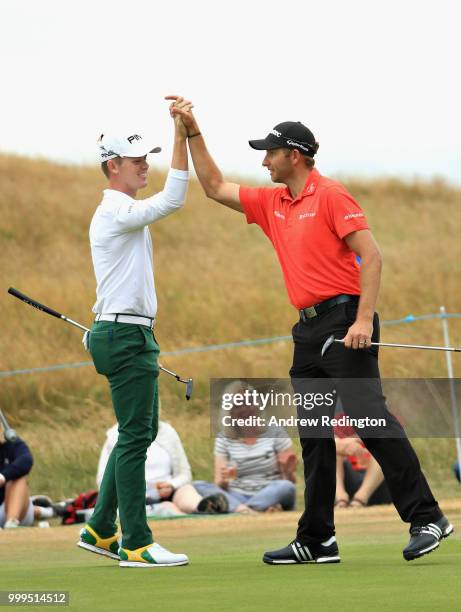 Brandon Stone of South Africa is congratulated for his eagle putt on hole sixteen by Dean Burmester of South Africa during day four of the Aberdeen...