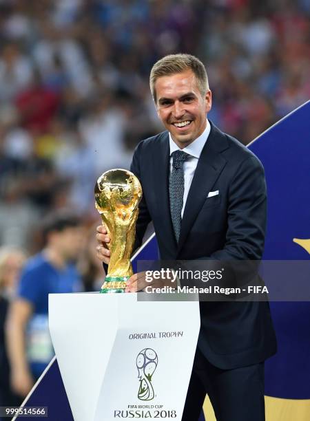 Former football player Philippe Lahm takes the World Cup trophy on the stage for the winning ceremony following the 2018 FIFA World Cup Final between...