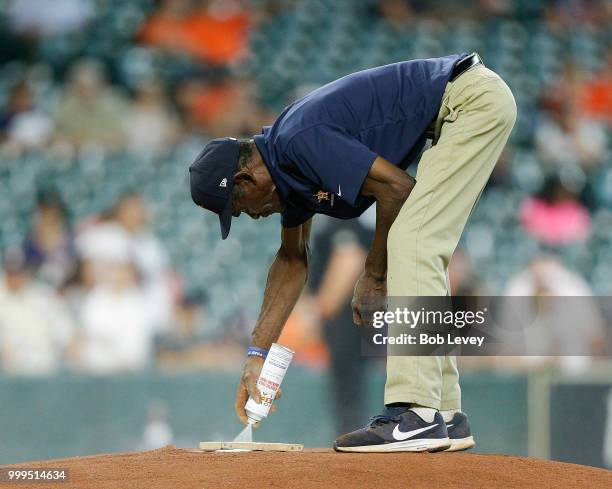 Houston Astros groundskeeper Willie Berry prepares the mound as the Detroit Tigers take on the Houston Astros at Minute Maid Park on July 15, 2018 in...