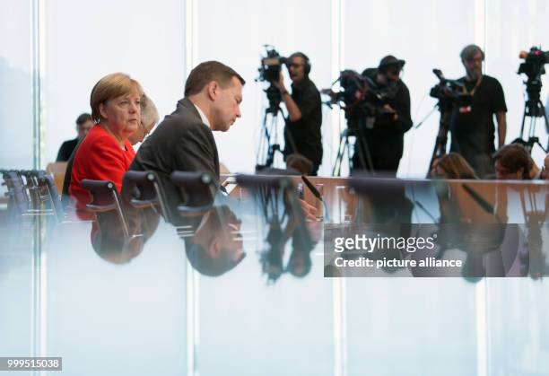 German Chancellor Angela Merkel speaks on current topics of interior and exterior policies next to governmental spokesman Steffen Seibert at the...