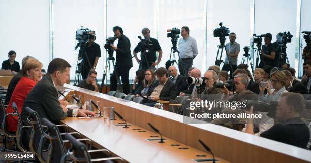 German Chancellor Angela Merkel speaks on current topics of interior and exterior policies next to governmental spokesman Steffen Seibert at the...