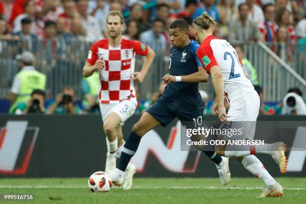 France's forward Kylian Mbappe and Croatia's defender Domagoj Vida vie for the ball during the Russia 2018 World Cup final football match between...