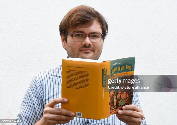 Jonathan Voges, scientific assistant at the Historical Institute of the Leibniz University Hanover holds up his monography "Men do it themselves" in...