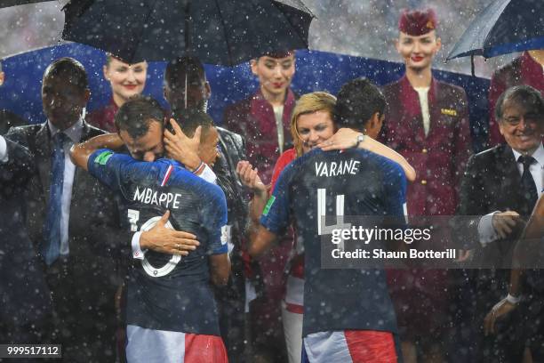 French President Emmanuel Macron and Croatia's President Kolinda Grabar-Kitarovic hug Kylian Mbappe anf Raphael Varane of France during the 2018 FIFA...