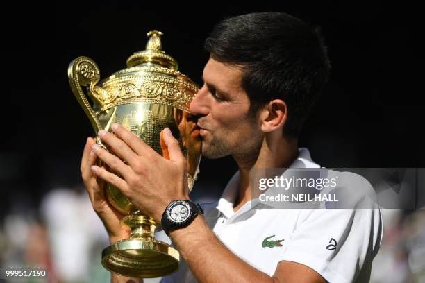 Serbia's Novak Djokovic kisses the winners trophy after beating South Africa's Kevin Anderson 6-2, 6-2, 7-6 in their men's singles final match on the...