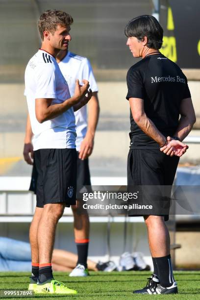 German player Thomas Mueller is taking to national coach Joachim Loew during a training session of the German national soccer team on the training...