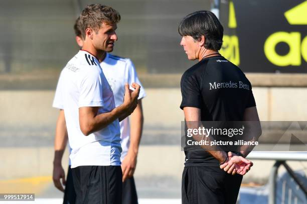 Dpatop - German player Thomas Mueller is taking to national coach Joachim Loew during a training session of the German national soccer team on the...