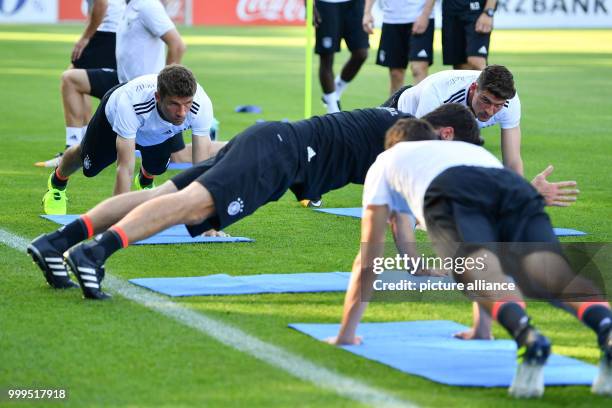 Thomas Mueller , Mario Gomez and other German national players do warm-ups during a training session of the German national soccer team on the...