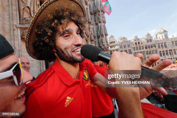Belgium's Eden Hazard holds the microphone for Marouane Fellaini as they celebrate at the balcony in front of more than 8000 supporters at the...
