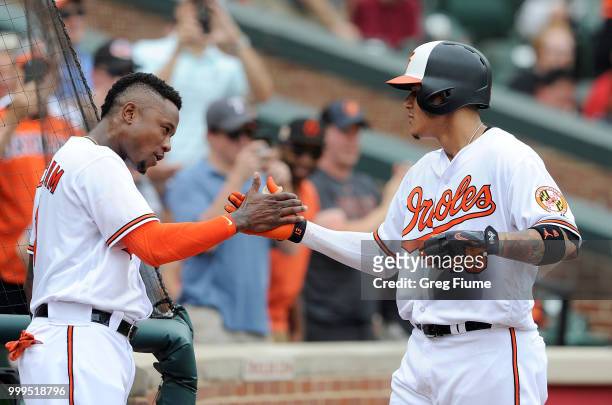 Manny Machado of the Baltimore Orioles celebrates with Tim Beckham after hitting a home run in the first inning against the Texas Rangers at Oriole...