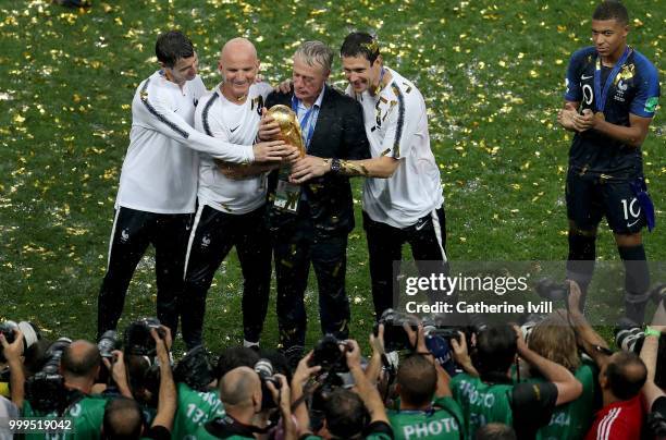 Didier Deschamps, Manager of France and Guy Stephan, France Assistan Coach, celebrate with their staff and the World Cup Trophy following their sides...