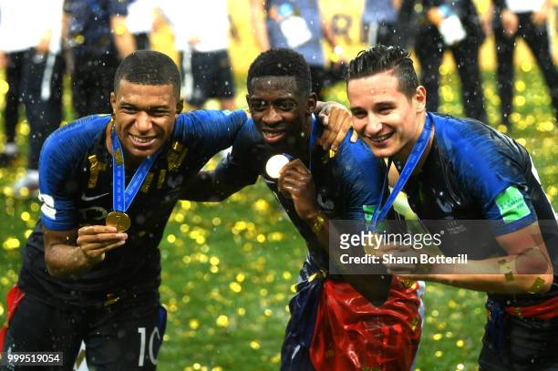 Kylian Mbappe, Thomas Lemar and Florian Thauvin of France show their medals following victory in the 2018 FIFA World Cup Final between France and...