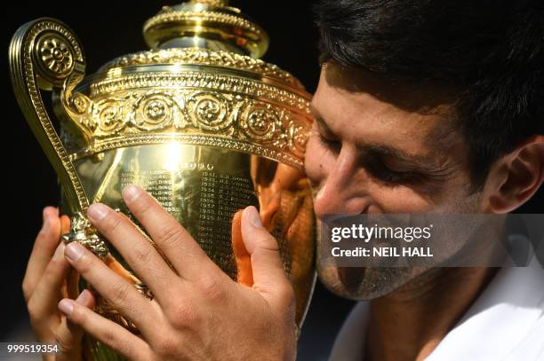 Serbia's Novak Djokovic poses with the winners trophy after beating South Africa's Kevin Anderson 6-2, 6-2, 7-6 in their men's singles final match on...