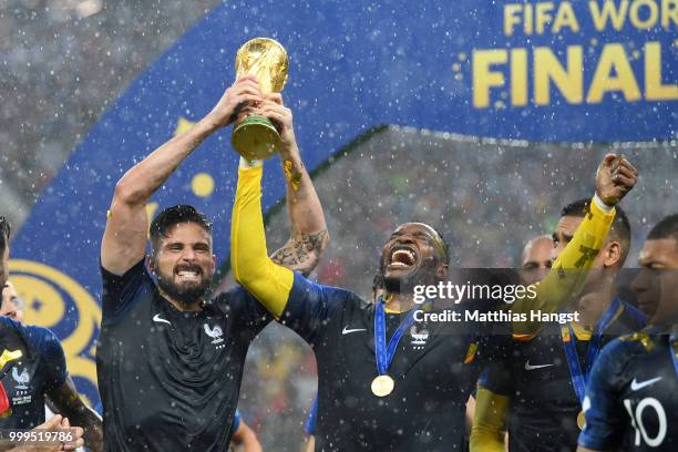 Olivier Giroud of France and Steve Mandanda of France celebrate with the World Cup Trophy following their sides victory in the 2018 FIFA World Cup...