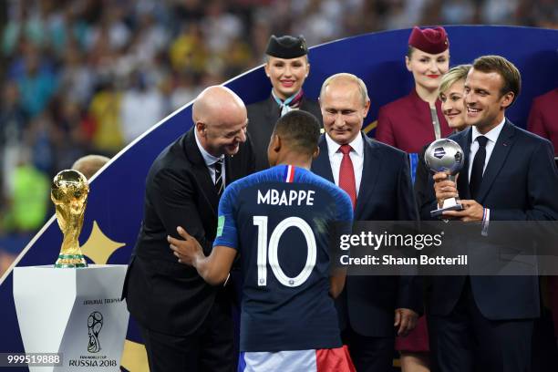 French President Emmanuel Macron awards Kylian Mbappe of France with the FIFA Young Player Award following the 2018 FIFA World Cup Final between...