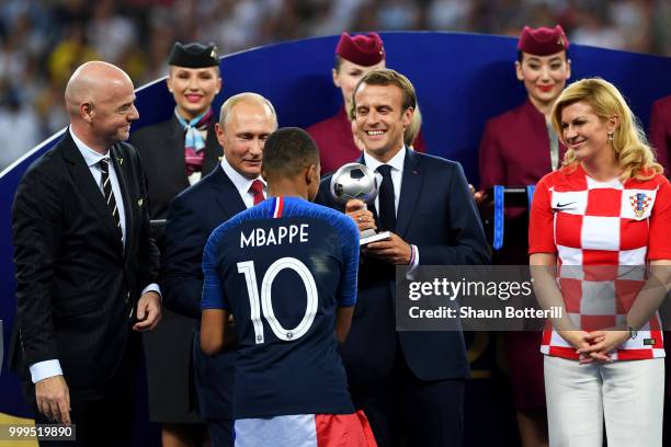 French President Emmanuel Macron awards Kylian Mbappe of France with the FIFA Young Player Award following the 2018 FIFA World Cup Final between...