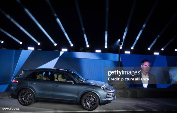 New Porsche Cayenne is standing on the stage next to a picture of Porsche CEO Oliver Blume during the presentation of the new series in Stuttgart,...