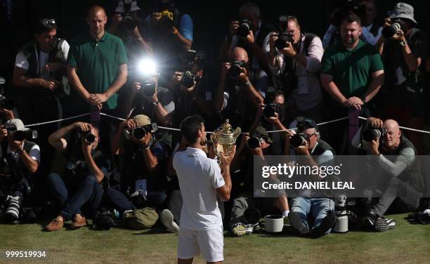 Serbia's Novak Djokovic holds the winners trophy after beating South Africa's Kevin Anderson 6-2, 6-2, 7-6 in their men's singles final match on the...