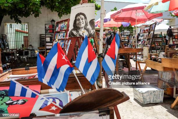 June 2019, Cuba, Havana: Cuban flags pictured at the Plaza de Armas book market, where mumerous used books, magazines, records, pictures and other...