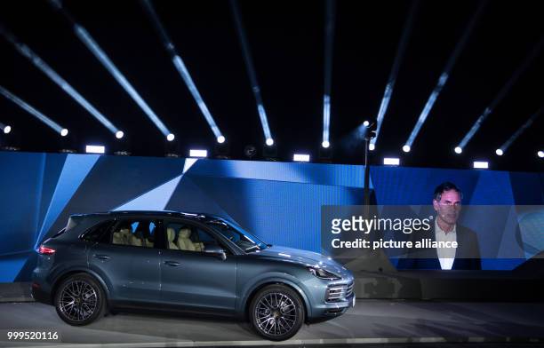 New Porsche Cayenne is standing on the stage next to a picture of Porsche CEO Oliver Blume during the presentation of the new series in Stuttgart,...