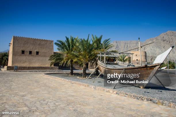 old dhow in front of khasab fort, khasab, musandam, oman - arabian peninsula stock-fotos und bilder