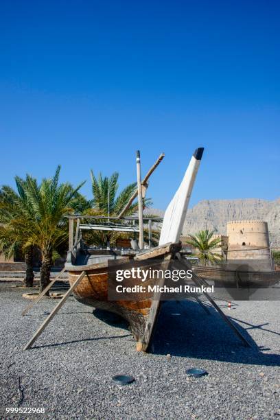 old dhow in front of khasab fort, khasab, musandam, oman - arabian peninsula stock pictures, royalty-free photos & images