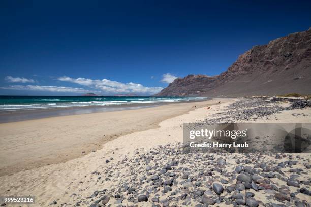 famara beach, playa de famara, with risco de famara, lanzarote, canary islands, spain - risco stock pictures, royalty-free photos & images