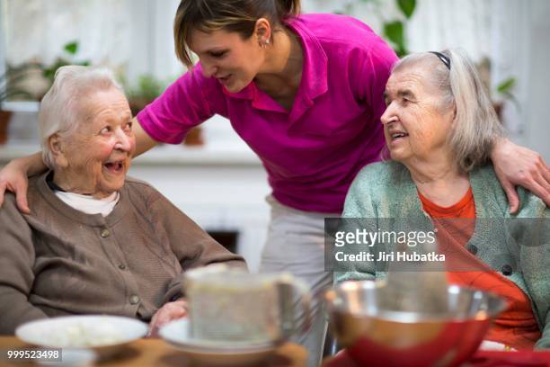 two elderly women, 78 years and 88 years, and a carer for the elderly, 31 years, leisure activities in a nursing home - 30 34 years stock-fotos und bilder