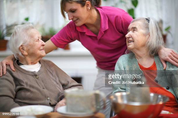 two elderly women, 78 years and 88 years, and a carer for the elderly, 31 years, leisure activities in a nursing home - 30 34 years stock pictures, royalty-free photos & images