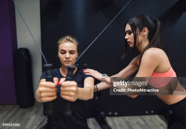 woman with personal trainer in fitness club - biological process stock pictures, royalty-free photos & images