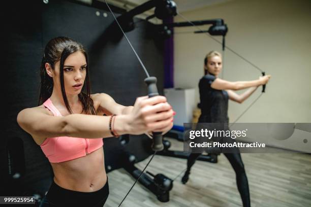 woman with personal trainer in fitness club - biological process stock pictures, royalty-free photos & images