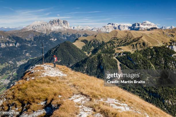 climber on the summit of cima dodici, sas da le doudesh in the val san nicolo di fassa, in the back the sasso lungo and sasso piatto and sella group, below the fassa valley, dolomites, trentino province, pozza di fassa, trentino-alto adige, italy - val senales imagens e fotografias de stock