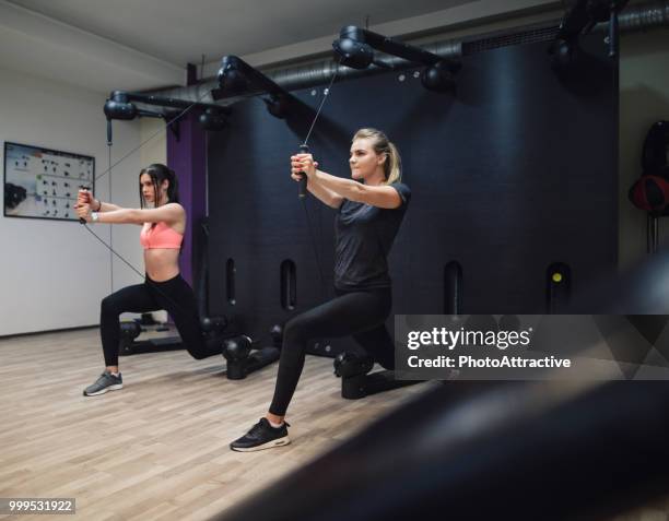 woman with personal trainer in fitness club - biological process imagens e fotografias de stock