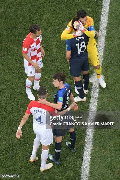 France's defender Benjamin Pavard greets Croatia's forward Ivan Perisic at the end of the Russia 2018 World Cup final football match between France...