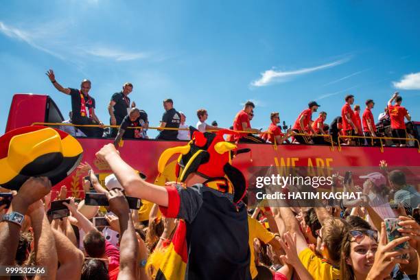 Supporters cheer as an open bus with the Red Devils pass by on their way to the Grand Place, Grote Markt in the city centre of Brussels, as Belgian...