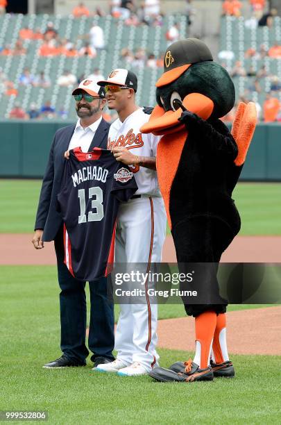 Manny Machado of the Baltimore Orioles is presented his All-Star jersey by Steve Eaves before the game against the Texas Rangers at Oriole Park at...