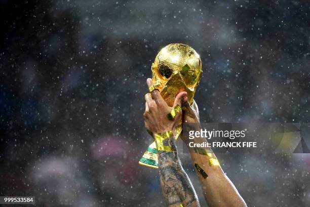 France's defender Djibril Sidibe raises their World Cup trophy during the trophy ceremony at the end of the Russia 2018 World Cup final football...
