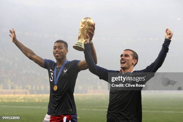 Presnel Kimpembe of France and Antoine Griezmann of France celebrate with the World Cup Trophy following their sides victory in the 2018 FIFA World...