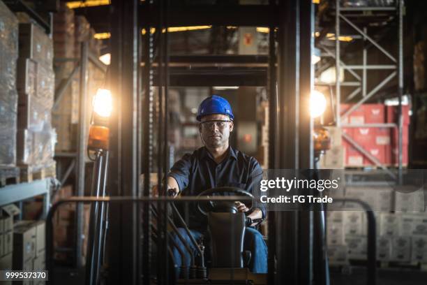 worker driving a forklift in warehouse - flat bed dolly stock pictures, royalty-free photos & images