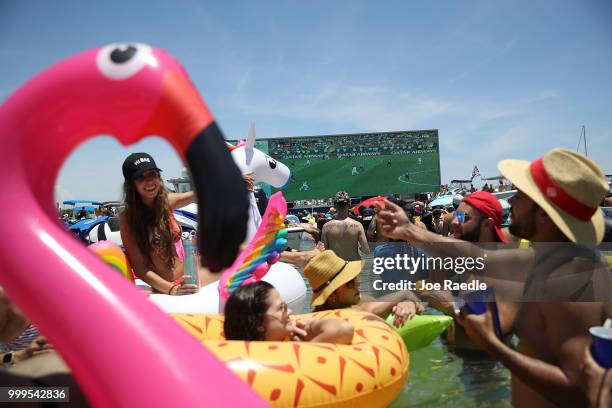 People watch France playing Croatia in the World Cup final as it is being broadcast from the Ballyhoo Media boat setup in the Intracoastal Waterway...