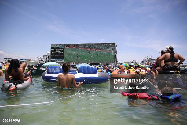 People watch France playing against Croatia in the World Cup final as it is being broadcast from the Ballyhoo Media boat setup in the Intracoastal...