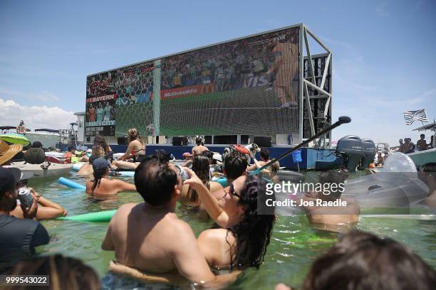 People watch France playing against Croatia in the World Cup final as it is being broadcast from the Ballyhoo Media boat setup in the Intracoastal...