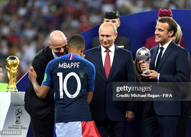 President Gianni Infantino, greets Kylian Mbappe of France as French President Emmanuel Macron prepares to present him with the FIFA Young Player...