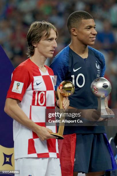 Kylian Mbappe of France and Luka Modric of Croatia poses with there respective Most promising player and man of the match awards after the final...