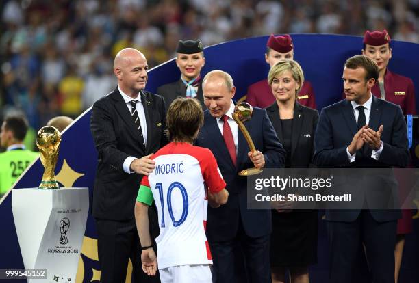 President of Russia Vladimir Putin greets Luka Modric of Croatia as FIFA President Gianni Infantino and French President Emmanuel Macron looks on...