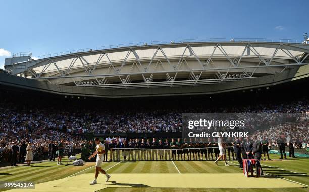 Serbia's Novak Djokovic carries the winners trophy after beating South Africa's Kevin Anderson 6-2, 6-2, 7-6 in their men's singles final match on...