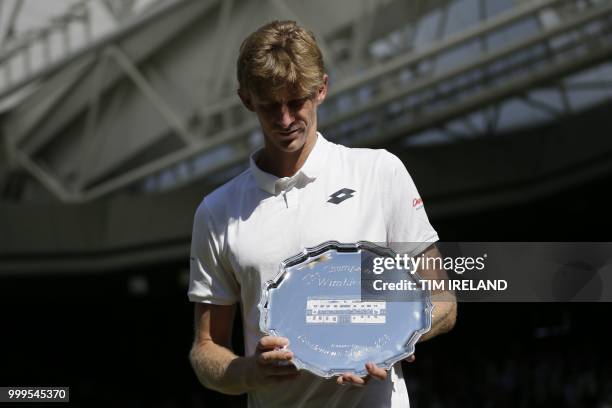 South Africa's Kevin Anderson holds his runners up dish after losing to Serbia's Novak Djokovic 6-2, 6-2, 7-6 in their men's singles final match on...